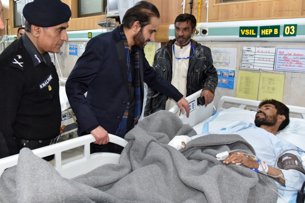 Chief Minister of Balochistan Mir Abdul Qudoos Bizenjo, speaks with a policeman receiving treatment, after he was injured in suicide bomb attack in Kachhi district, during his visit at a hospital in Quetta on March 6, 2023. (Photo by Banaras Khan / AFP)