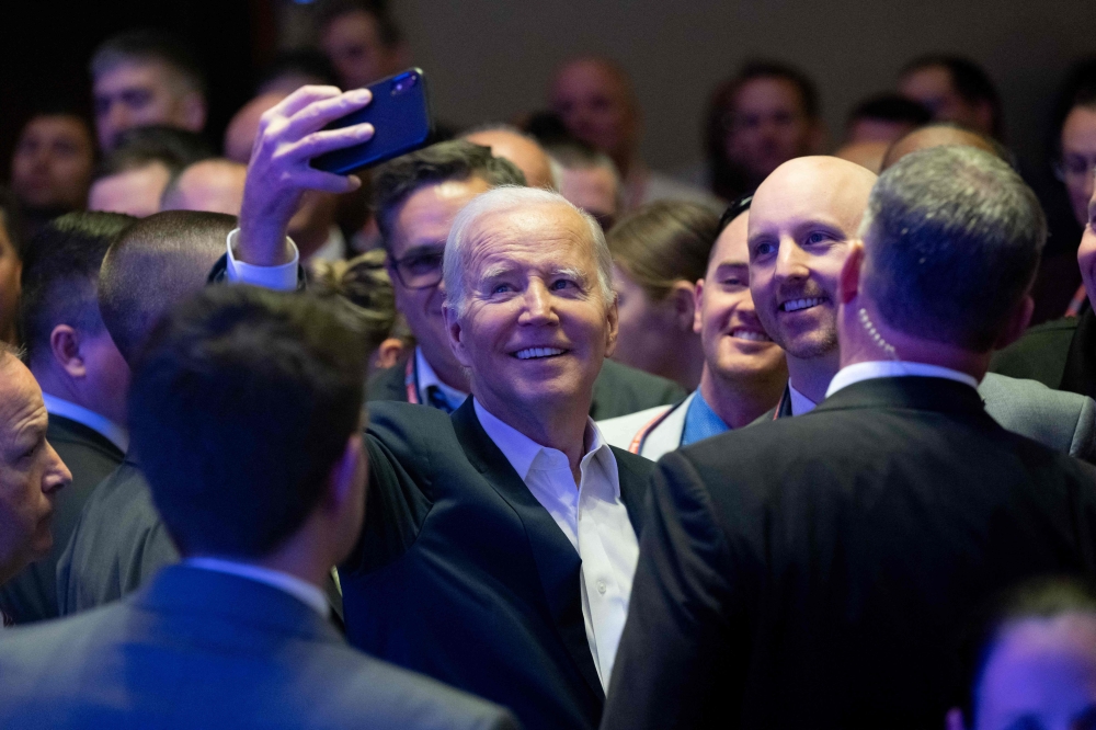 US President Joe Biden takes a selfie with attendees after speaking at the 2023 International Association of Fire Fighters Legislative Conference in Washington, DC, on March 6, 2023. (Photo by SAUL LOEB / AFP)