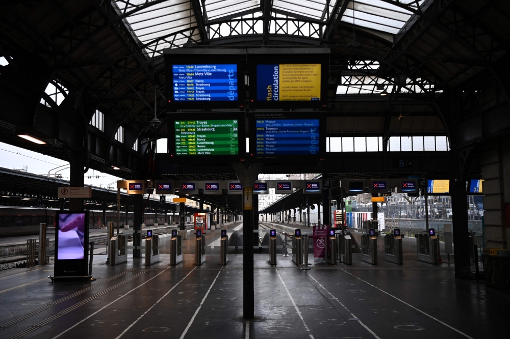 Screens display information above empty forecourts and platforms at the Gare de l'Est railway station in Paris, on March 7, 2023 (Photo by Christophe ARCHAMBAULT / AFP)