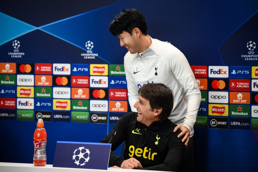Tottenham Hotspur's South Korean striker Son Heung-Min (R) jokes with Tottenham Hotspur's Italian head coach Antonio Conte (L) as he leaves during a press conference at the Tottenham Hotspur Football Club Training Ground, in Enfield, near London on March 7, 2023, on the eve of their UEFA Champions League round of 16 second-leg football match against AC Milan. (Photo by Daniel LEAL / AFP) 