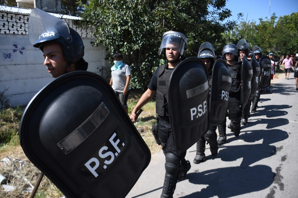Police arrive at the site where people loot and destroy the house of an alleged drug trafficker in Rosario, Santa Fe province, Argentina, on March 6, 2023, in protests over the killing of a child in the middle of a shooting while playing in the street last Saturday night. (Photo by STRINGER / AFP)