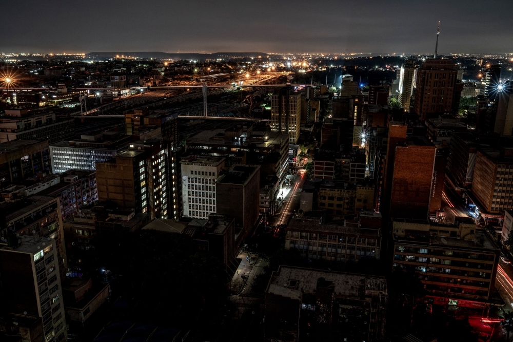 In this file photo taken on January 31, 2023 A general view of some parts of Braamfontein, Johannesburg submerged in darkness due to load-shedding (rolling blackout). Photo by AFP