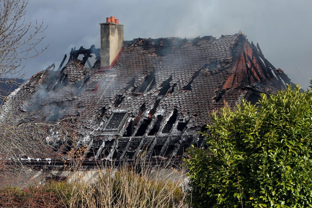 Smoke billows from the roof of a residential house that caught fire after a large explosion in Yverdon-les-Bains, western Switzerland, where 