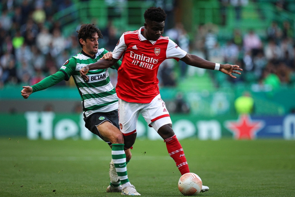 Sporting Lisbon's Portuguese forward Francisco Trincao (left) fights for the ball with Arsenal's English midfielder Bukayo Saka during the UEFA Europa League last 16 first leg football match between Sporting CP and Arsenal at Jose Alvalade stadium in Lisbon on March 9, 2023. (Photo by FILIPE AMORIM / AFP)