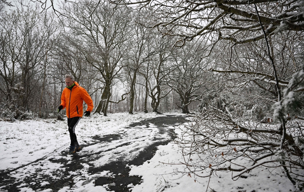 A runner braves the snow on Bidston Hill, near Birkenhead, in north west England on March 9, 2023. Photo by Paul ELLIS / AFP