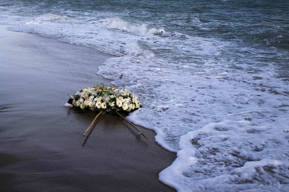 A wreath of flowers floats on the Mediterranean Sea, thrown by people who ended a protest march on the beach at the site of the shipwreck on March 11, 2023 in Steccato di Cutro, Calabria region, southern Italy, as part of the movement 'Stop the massacre, now!' (Fermare la strage, subito!) launched by the 'National Network February 26' created following the February 26, 2023 shipwreck that killed at least 74 migrants, including children, in Steccato di Cutro. (Photo by Gianluca CHININEA / AFP)