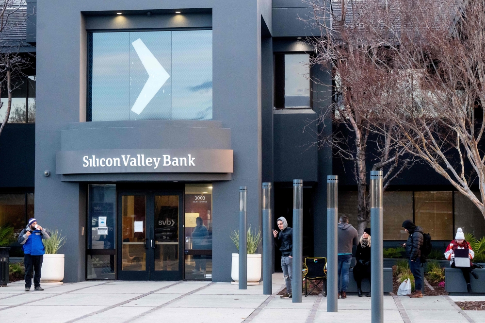 Silicon Valley Bank customers line up before the opening of a branch at SVB's headquarters in Santa Clara, California, on March 13, 2023.  (Photo by NOAH BERGER / AFP)
