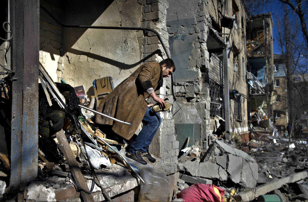 A local resident looks for his belongings after a shelling in Kramatorsk, eastern Ukraine, on March 14, 2023, amid the Russian invasion of Ukraine. Photo by Sergey SHESTAK / AFP