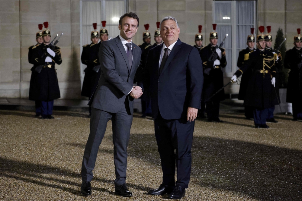 Fance's President Emmanuel Macron shakes hands with Hungarian Prime Minister Viktor Orban, before a working dinner at the Elysee Presidential Palace in Paris on March 13, 2023. (Photo by Ludovic MARIN / AFP)