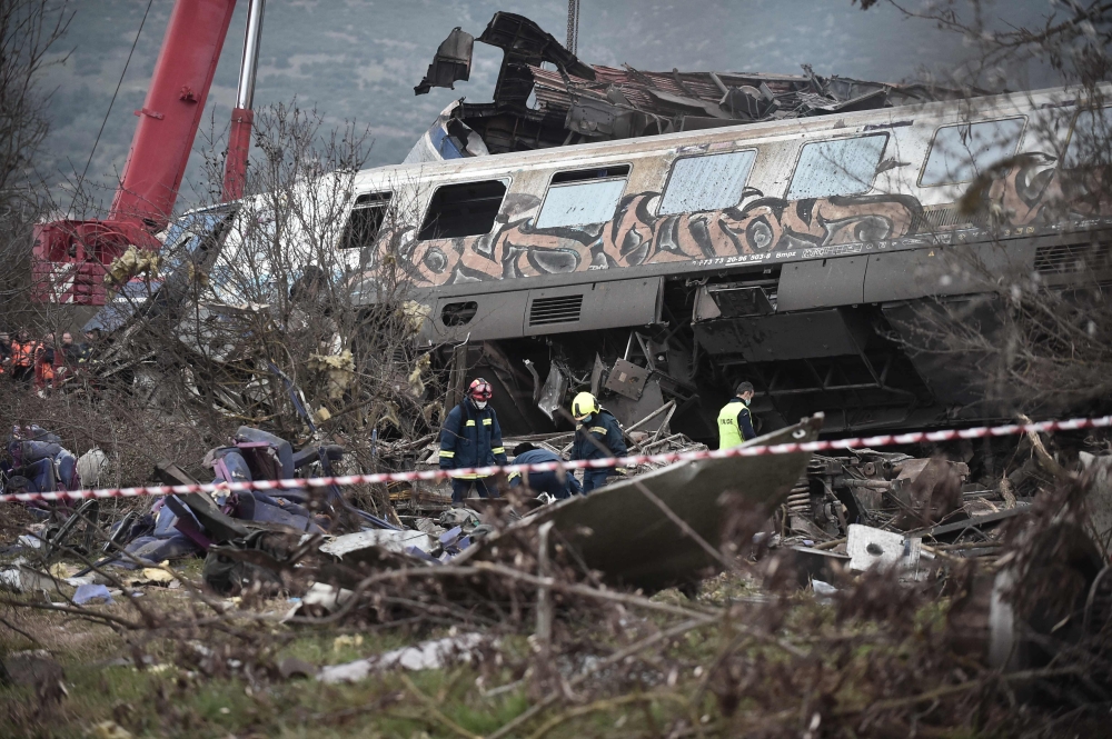 Police and emergency crew search the debris of a crushed wagon after a train accident in the Tempi Valley near Larisa, Greece, March 1, 2023. (Photo by Sakis Mitrolidis / AFP)