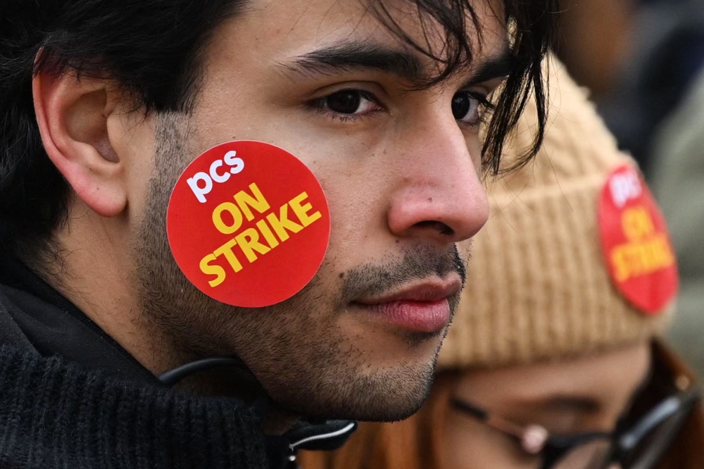 A demonstrator takes part in a protest called by the British trade union Public and Commercial Services Union (PCS) amid a dispute with the government over pay, outside Downing Street in London, on March 15, 2023. (Photo by JUSTIN TALLIS / AFP)