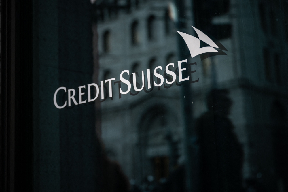 A sign of Credit Suisse bank is seen on the branch building in Geneva, on March 15, 2023. - Credit Suisse shares nosedived on March 15, 2023, after its main shareholder said it would not provide more funding, with reassuring comments from the Swiss bank's chairman unable to calm the market panic. (Photo by Fabrice COFFRINI / AFP)