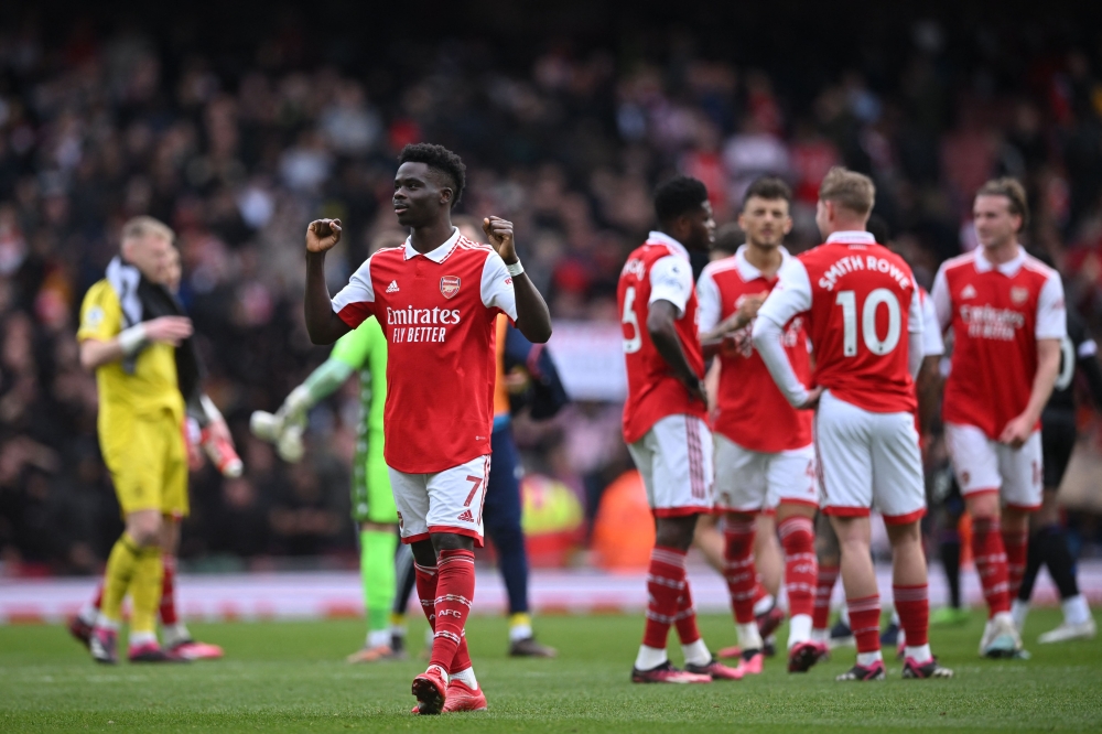 Arsenal's English midfielder Bukayo Saka gestures to fans on the pitch after the English Premier League football match between Arsenal and Crystal Palace at the Emirates Stadium in London on March 19, 2023. - Arsenal won the game 4-1. (Photo by JUSTIN TALLIS / AFP)