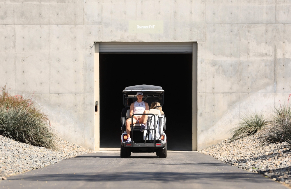  Iga Swiatek of Poland heads to her match via a golf buggy during the BNP Paribas Open on March 16, 2023 in Indian Wells, California. Julian Finney/Getty Images/AFP