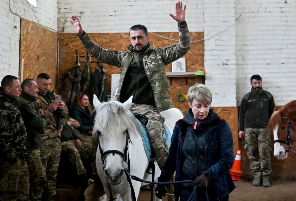  A Ukrainian serviceman rides a horse during a hippotherapy session in Kyiv on March 17, 2023. Photo by Sergei SUPINSKY / AFP