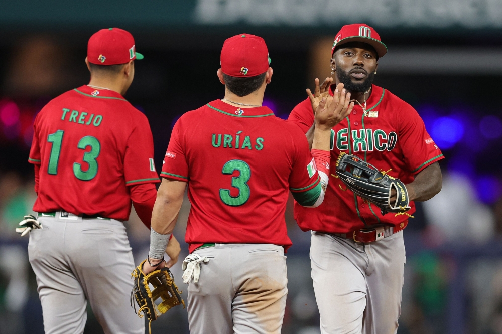 Luis Urias #3 and Randy Arozarena #56 of Team Mexico high five during the third inning against Team Mexico during the World Baseball Classic Semifinals at loanDepot park on March 20, 2023 in Miami, Florida. Megan Briggs/Getty Images/AFP