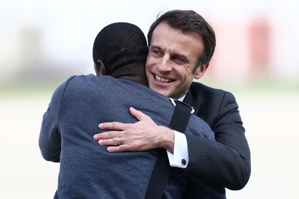 French President Emmanuel Macron greets freed French hostage journalist Olivier Dubois, who was held hostage in Mali for nearly two years by the Support Group for Islam and Muslims (GSIM), upon his arrival at the Villacoublay airport, in Velizy-Villacoublay, near Paris, on March 21, 2023. - French journalist Olivier Dubois was released on March 20, 2023. (Photo by YVES HERMAN / POOL / AFP)