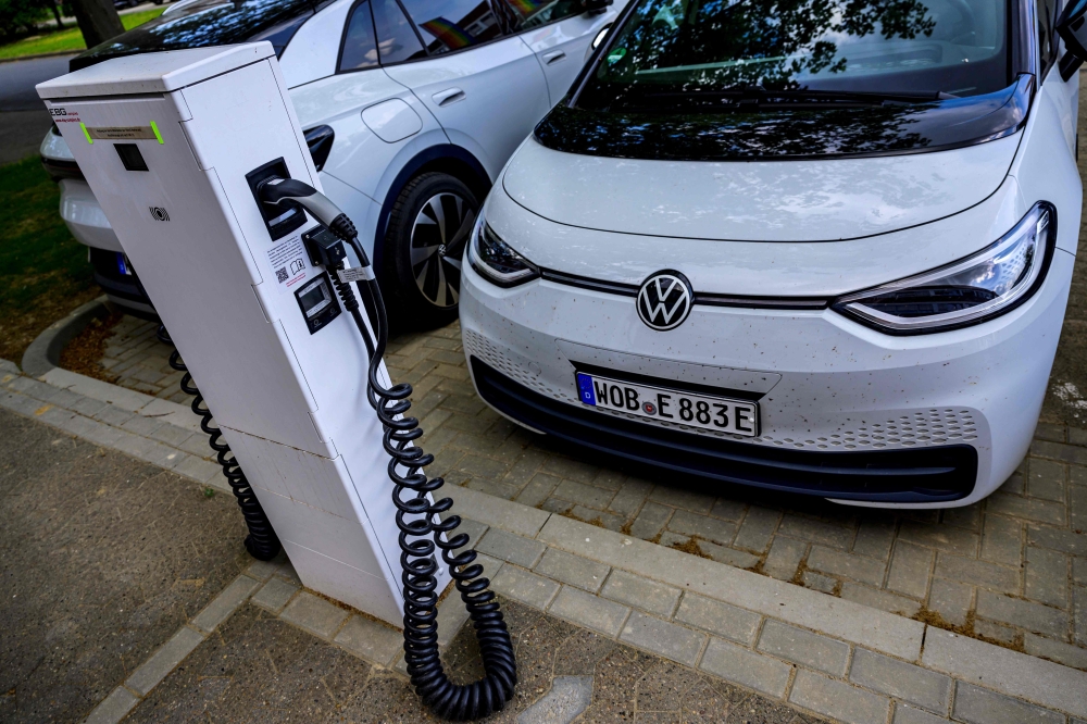 (FILES) In this file photo taken on May 18, 2022 a Volkswagen electric car is parked in front of a charging station at VW's component plant in Salzgitter, north-central Germany. (Photo by John MacDougall / AFP)
