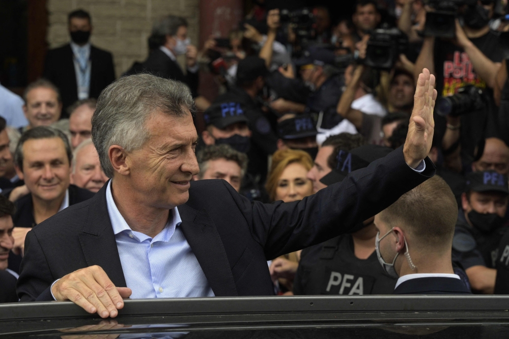 In this file photo taken on November 03, 2021, Argentina's former President Mauricio Macri waves after leaving the federal court in Dolores, Buenos Aires province. (Photo by JUAN MABROMATA / AFP)