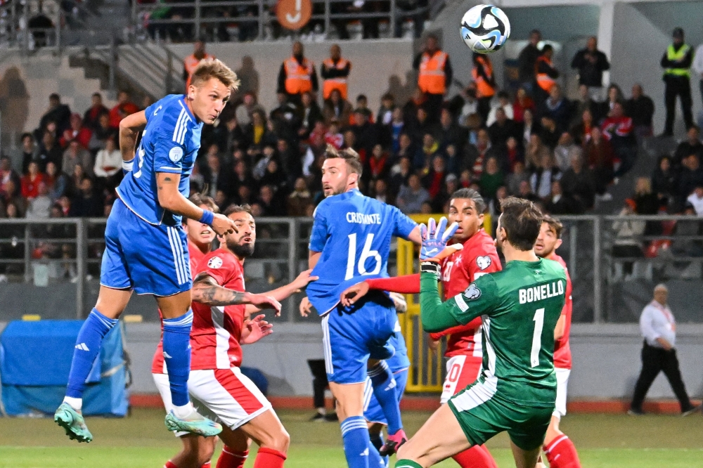 Italy's forward Mateo Retegui (L) scores his team's first goal by a header during the UEFA Euro 2024 Group C qualification match between Malta and Italy, at the National stadium in Ta'Qali, Malta, on March 26, 2023. Photo by Alberto PIZZOLI / AFP