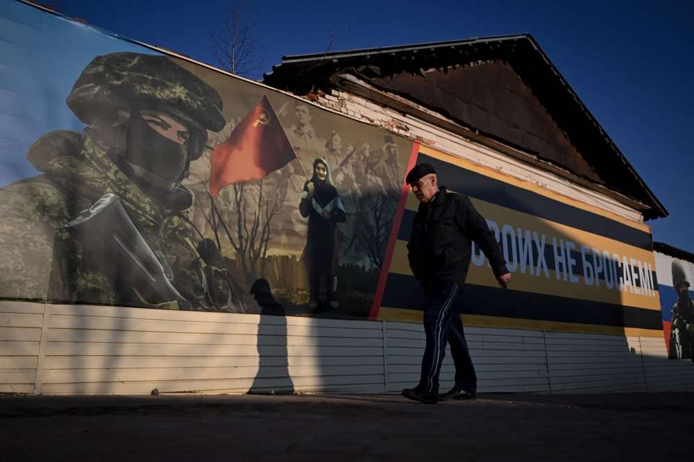 A man walks past a patriotic banner reading 