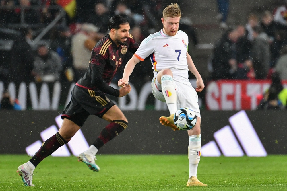 Belgium's midfielder Kevin De Bruyne (right) and Germany's midfielder Emre Can vie for the ball during the international friendly football match Germany v Belgium in Cologne, western Germany, on March 28, 2023. (Photo by UWE KRAFT / AFP)