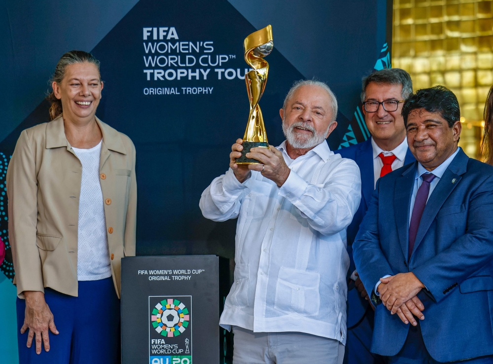 This handout picture released by the Brazilian Presidency shows Brazil's President Luiz Inacio Lula da Silva (centre), accompanied by the Sports Minister Ana Moser (left) and the President of the Brazilian Football Confederation Ednaldo Rodrigues, holding the FIFA Women's World Cup trophy during its presentation at the Planalto Palace in Brasilia on March 30, 2023. (Photo by Ricardo Stuckert / Brazilian Presidency / AFP) 