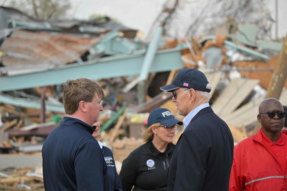 US President Joe Biden speaks with Mississippi Governor Tate Reeves (L) in Rolling Fork, Mississippi, on March 31, 2023. (Photo by Mandel NGAN / AFP)
