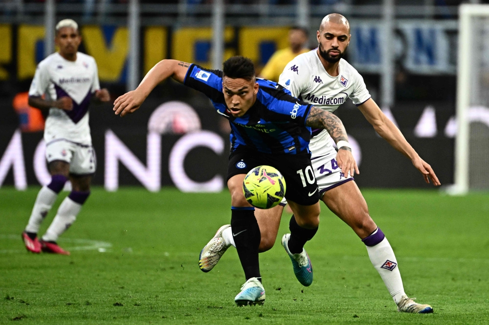 Inter Milan's Argentinian forward Lautaro Martinez (C) outruns Fiorentina's Moroccan midfielder Sofyan Amrabat (R) during the Italian Serie A football match between Inter and Fiorentina on April 1, 2023 at the Giuseppe-Meazza (San Siro) stadium in Milan. (Photo by GABRIEL BOUYS / AFP)