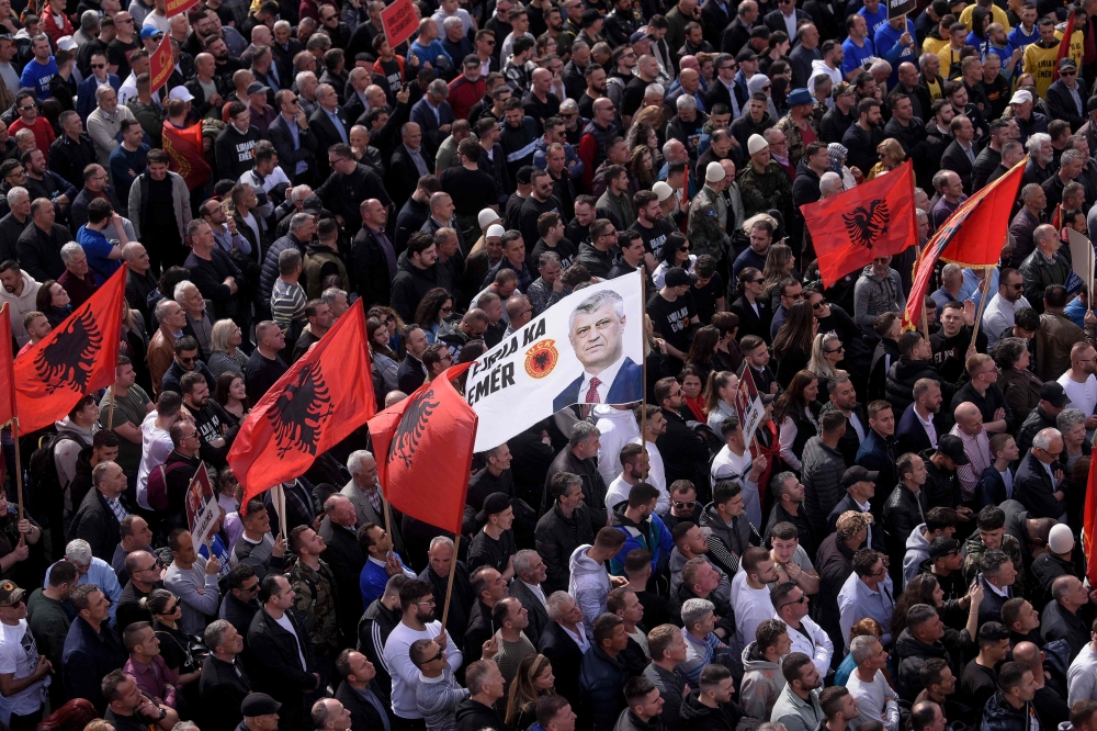 Kosovo Albanians wave Albanian flags and a flag depicting former Kosovo President Hashim Thaci as they take part in a march in Pristina on April 2, 2023. (Photo by Armend Nimani / AFP)

