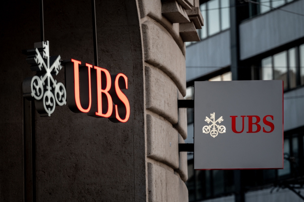 Signs of Swiss bank giant UBS bank are seen in Basel, on April 4, 2023 on the eve of the general meeting of shareholders following the takeover by UBS of Credit Suisse hastily arranged by the Swiss government on March 19, 2023 to prevent a financial meltdown. (Photo by Fabrice COFFRINI / AFP)