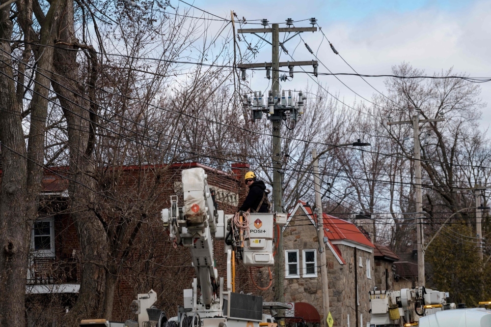 Hydro Quebec employees work on power lines on April 7, 2023, in Montreal, Canada after freezing rain hit parts of Quebec and Ontario on April 5. (Photo by ANDREJ IVANOV / AFP)