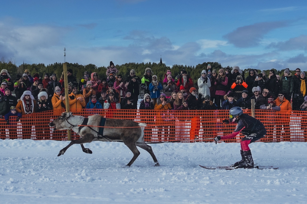 Spectators watch a reindeer and jockey compete in the finals of the PoroCup, a Finnish reindeer race on the frozen lake of Inari, Finland on April 9, 2023. (Photo by Alessandro Rampazzo / AFP)