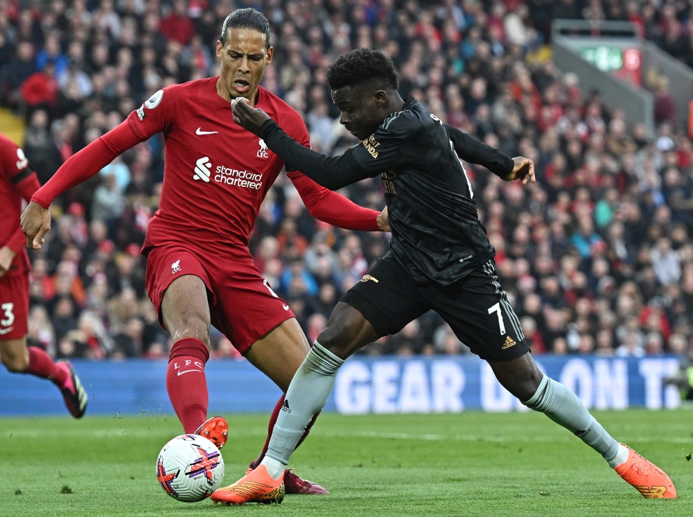 Liverpool's Dutch defender Virgil van Dijk (L) vies with Arsenal's English midfielder Bukayo Saka during the English Premier League football match between Liverpool and Arsenal at Anfield in Liverpool, north west England on April 9, 2023. (Photo by Paul ELLIS / AFP) 