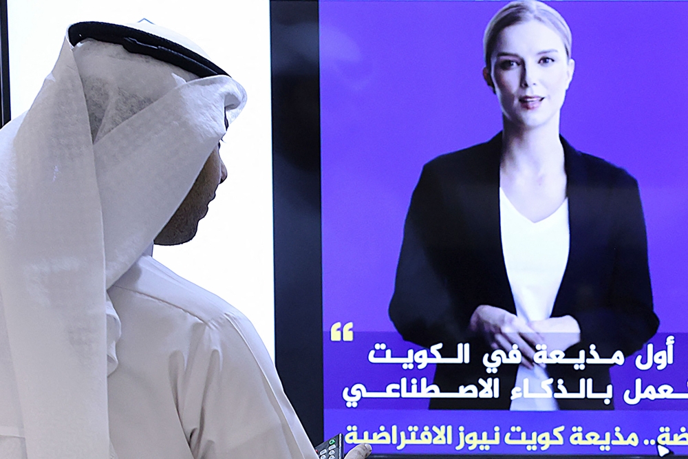A journalist watches an introductory video by the 'artificial intelligence' anchor Fedha on the twitter account of Kuwait News service, in Kuwait City on April 9, 2023. (Photo by YASSER AL-ZAYYAT / AFP)