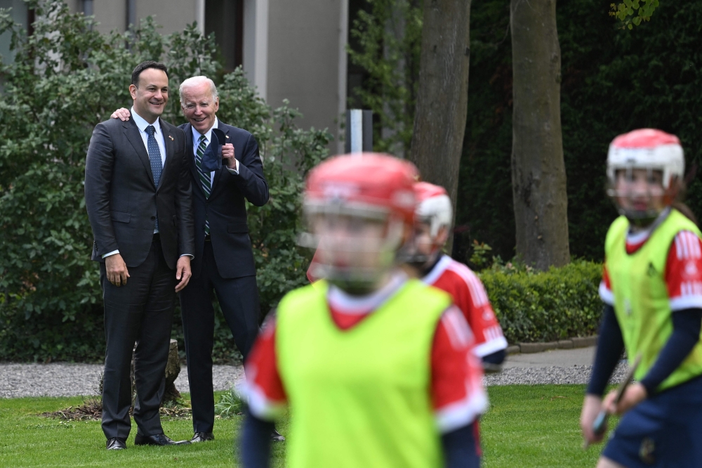 Ireland's Prime Minister Leo Varadkar (left) and US President Joe Biden chat as they watch school children playing Gaelic sports in the field behind Farmleigh House, in Dublin, on April 13, 2023, during his four-day trip to Northern Ireland and Ireland commemorating the 25th anniversary of the 
