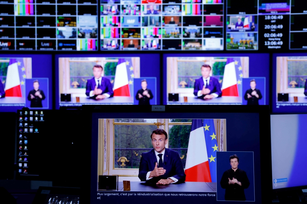 A photo of monitors in a media control room shows French President Emmanuel Macron during a televised address to the nation, made from the Elysee Palace, after signing into law a pensions reform, in Paris, on April 17, 2023. (Photo by Ludovic MARIN / AFP)
 