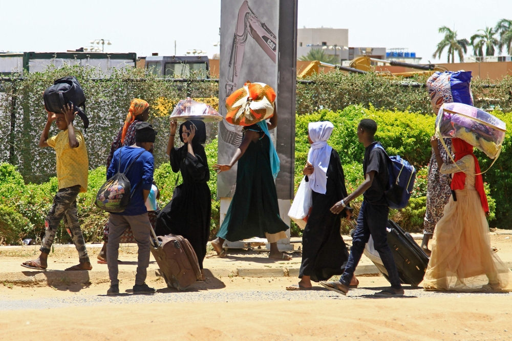 People flee from southern Khartoum on April 18, 2023 as fighting between the army and paramilitary forces led by rival generals rages for a fourth day, despite growing international calls for an end to hostilities. (Photo by AFP)