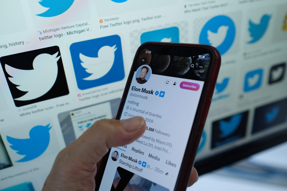 This illustration photo taken in Los Angeles on April 20, 2023, shows Elon Musk's blue tick next to his name on a smartphone. (Photo by Chris Delmas / AFP)

