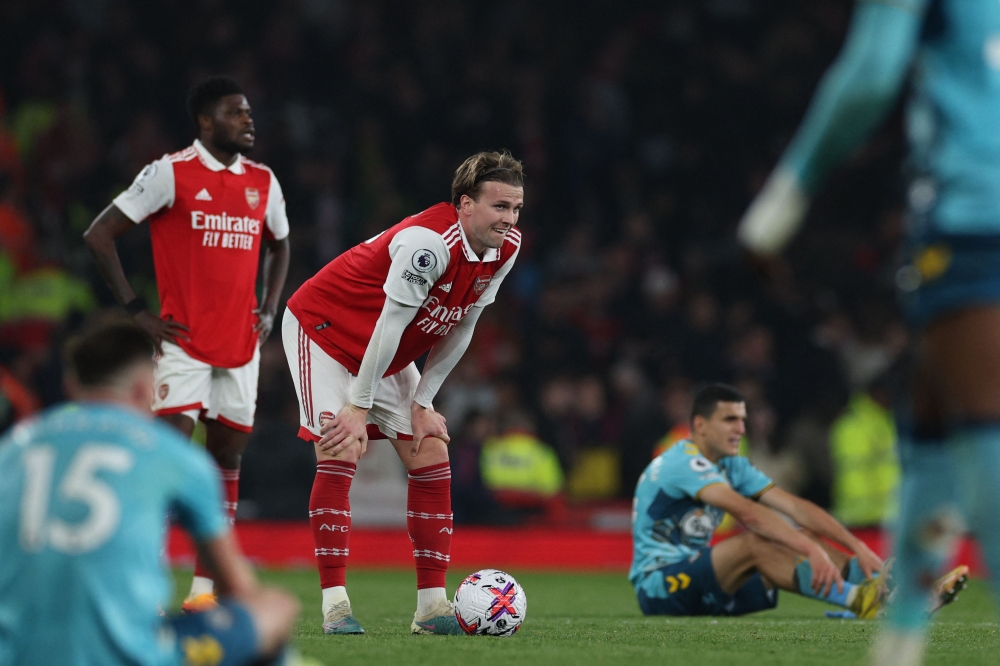 Arsenal's English defender Rob Holding (C) reacts on the pitch after the English Premier League football match between Arsenal and Southampton at the Emirates Stadium in London on April 21, 2023. - The game finished 3-3. (Photo by Adrian DENNIS / AFP) 