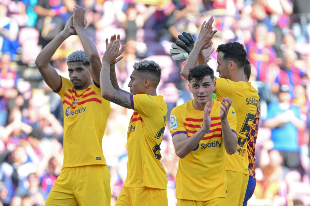 (From L) Barcelona's Uruguayan defender Ronald Araujo, Barcelona's Brazilian forward Raphinha, Barcelona's Spanish midfielder Pedri and Barcelona's Spanish midfielder Sergio Busquets applaud at the end of the Spanish league football match between FC Barcelona and Club Atletico de Madrid at the Camp Nou stadium in Barcelona on April 23, 2023. (Photo by LLUIS GENE / AFP)