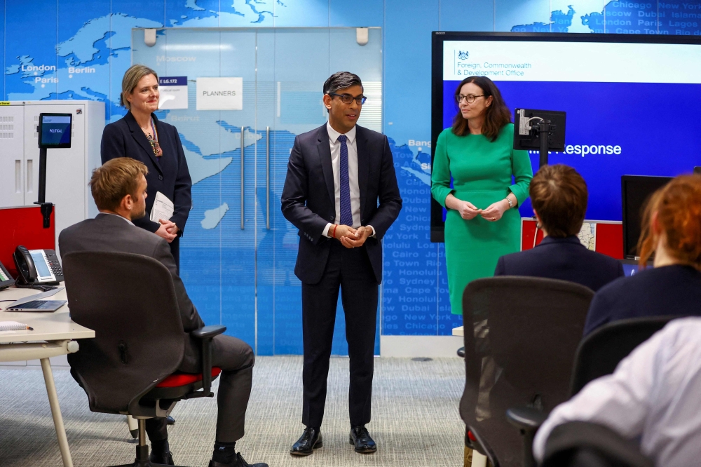 Britain's Prime Minister Rishi Sunak (centre) meets with teams coordinating the evacuation of British nationals from Sudan at the FCDO Crisis Centre, in London, April 25, 2023. (Photo by HANNAH MCKAY / POOL / AFP)