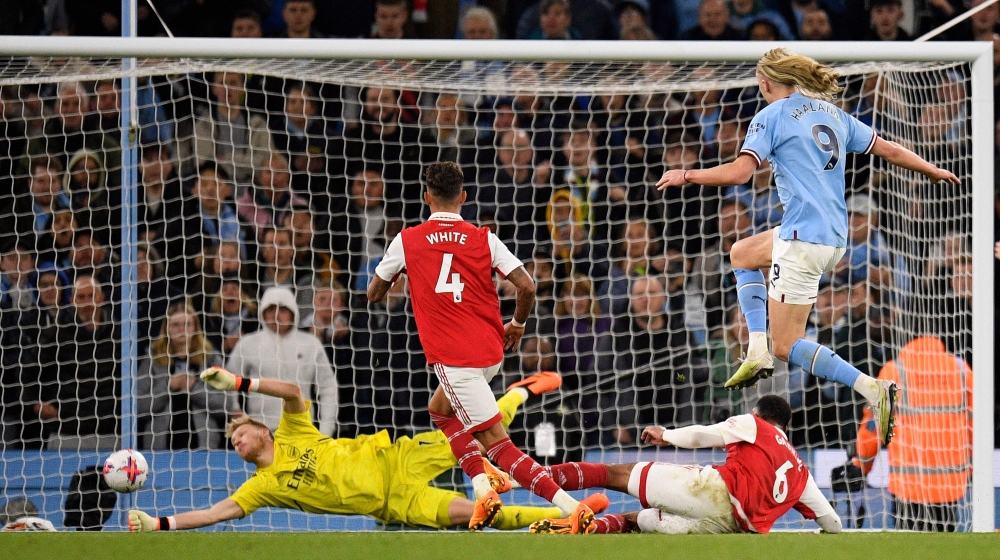 Manchester City's Norwegian striker Erling Haaland (R) scores the team's fourth goal during the English Premier League football match between Manchester City and Arsenal at the Etihad Stadium in Manchester, north west England, on April 26, 2023. (Photo by Oli SCARFF / AFP). 

