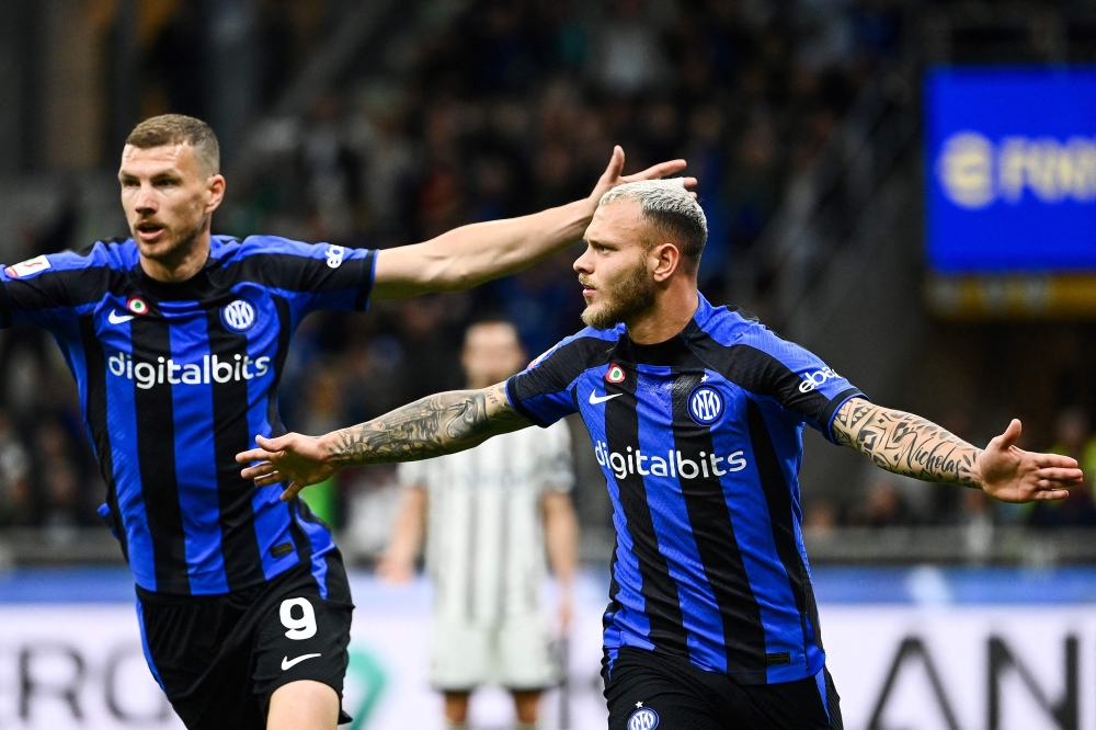 Inter Milan's Italian defender Federico Dimarco (R) celebrates after scoring his team's first goal during the Italian Cup semi-final second leg football match between Inter Milan and Juventus at the Giuseppe-Meazza (San Siro) stadium in Milan, on April 26, 2023. (Photo by Isabella BONOTTO / AFP)
