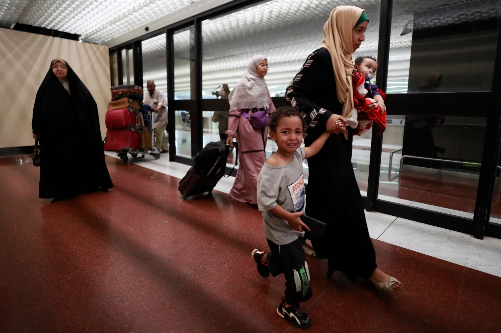People evacuated from Sudan arrive at Baghdad International Airport on April 27, 2023. (Photo by AHMED AL-RUBAYE / AFP)
