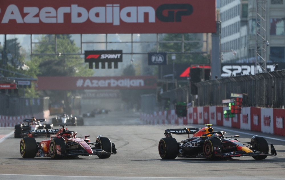 Red Bull Racing's Mexican driver Sergio Perez and Ferrari's Monegasque driver Charles Leclerc steer their cars during the sprint race ahead of the Formula One Azerbaijan Grand Prix at the Baku City Circuit in Baku on April 29, 2023. (Photo by Giuseppe CACACE / AFP)