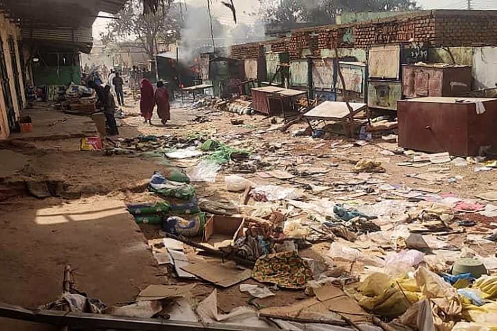 People walk among scattered objects in the market of El Geneina, the capital of West Darfur, as fighting continues in Sudan between the forces of two rival generals, on April 29, 2023.  Photo by AFP
