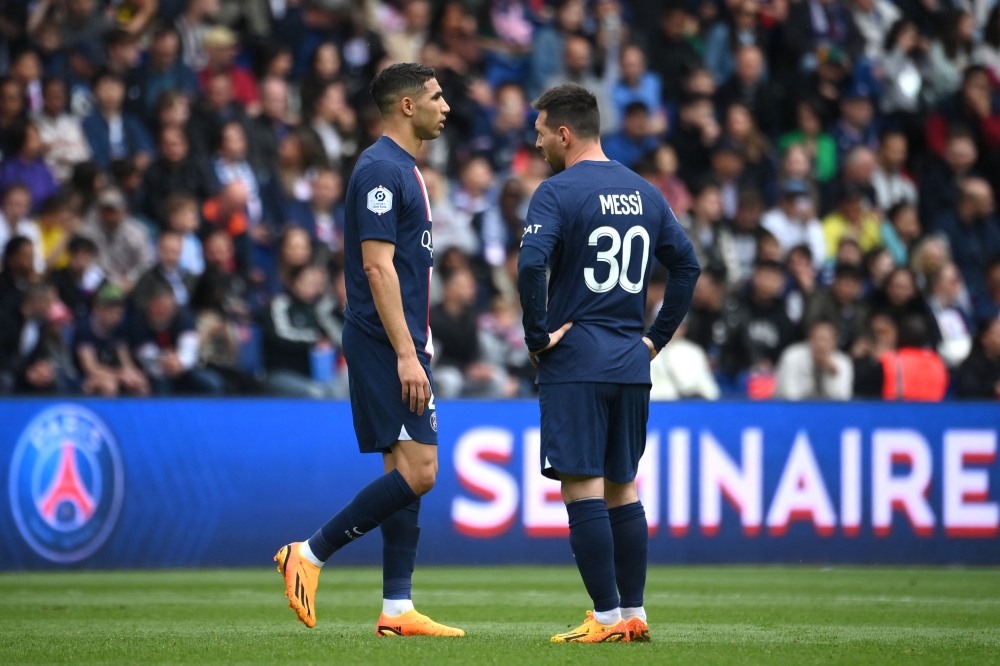 Paris Saint-Germain's Moroccan defender Achraf Hakimi (L) reacts next to Paris Saint-Germain's Argentine forward Lionel Messi (R) after receiving a second yellow card resulting in his being sent off during the French L1 football match between Paris Saint-Germain (PSG) and FC Lorient at The Parc des Princes Stadium in Paris on April 30, 2023. (Photo by FRANCK FIFE / AFP)