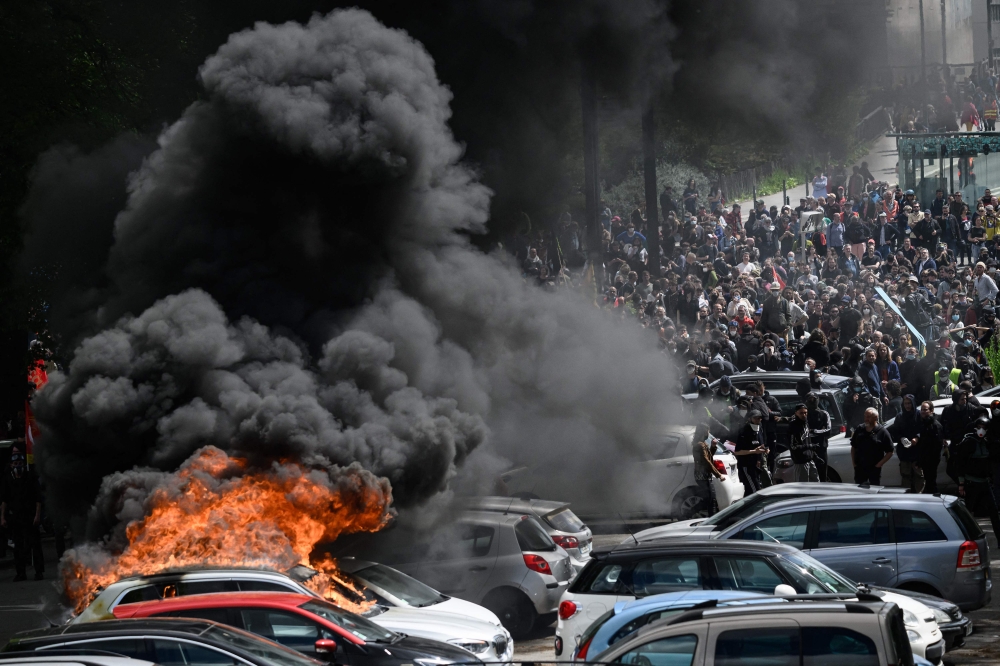 Cars are set on fire during a demonstration on May Day (Labour Day), to mark the international day of workers, more than a month after the government pushed an unpopular pensions reform act through parliament, in Nantes, northwestern France, on May 1, 2023. (Photo by LOIC VENANCE / AFP)