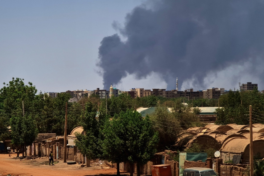 Smoke billows over buildings in Khartoum on May 1, 2023 as deadly clashes between rival generals' forces have entered their third week (Photo by AFP)